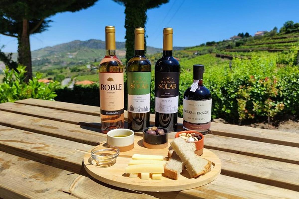 four bottles of wine and cheese on a wooden table