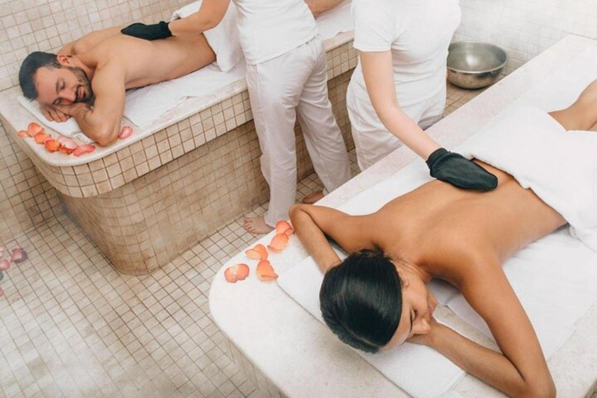 Una mujer tumbada en una bañera con dos personas.