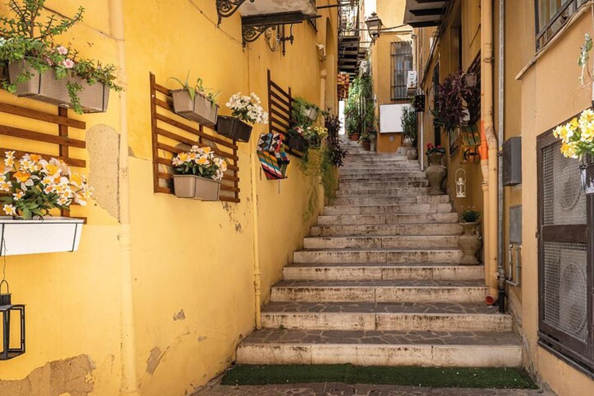 an alley in an italian town with stairs and flowers