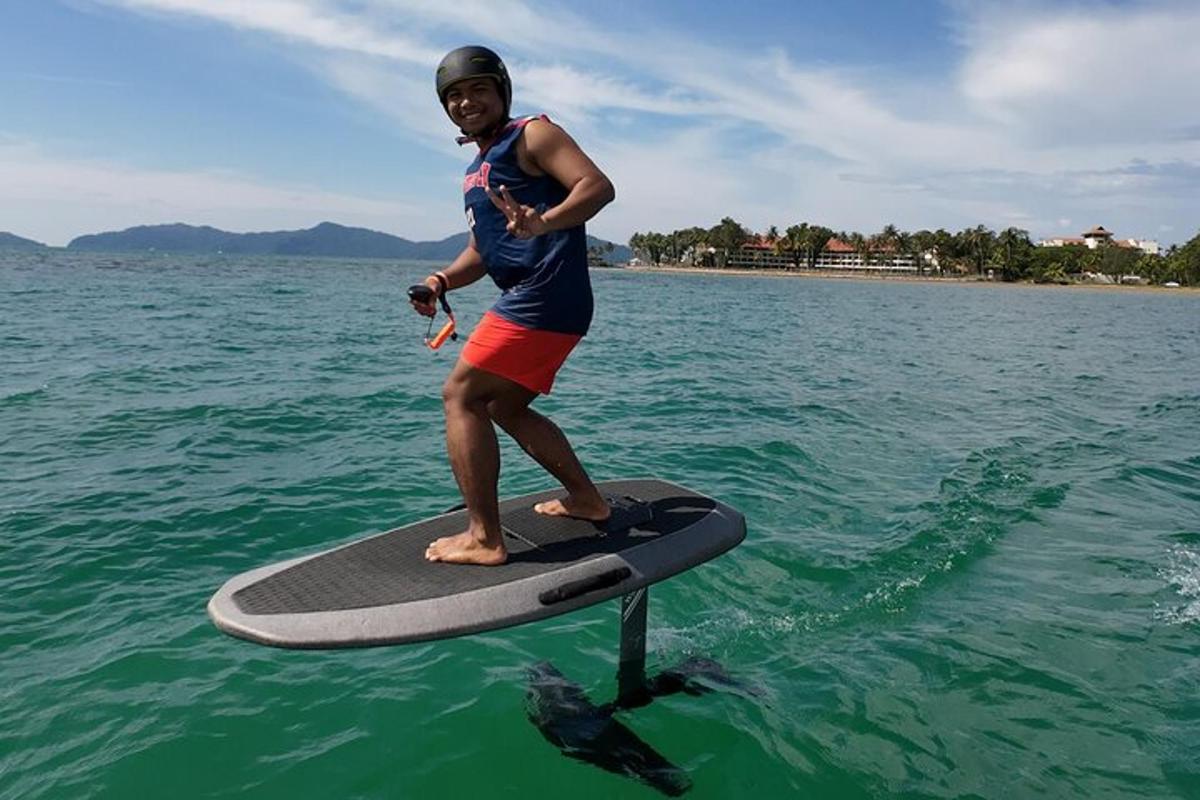 moški, ki stoji na deski za surfanje v vodi