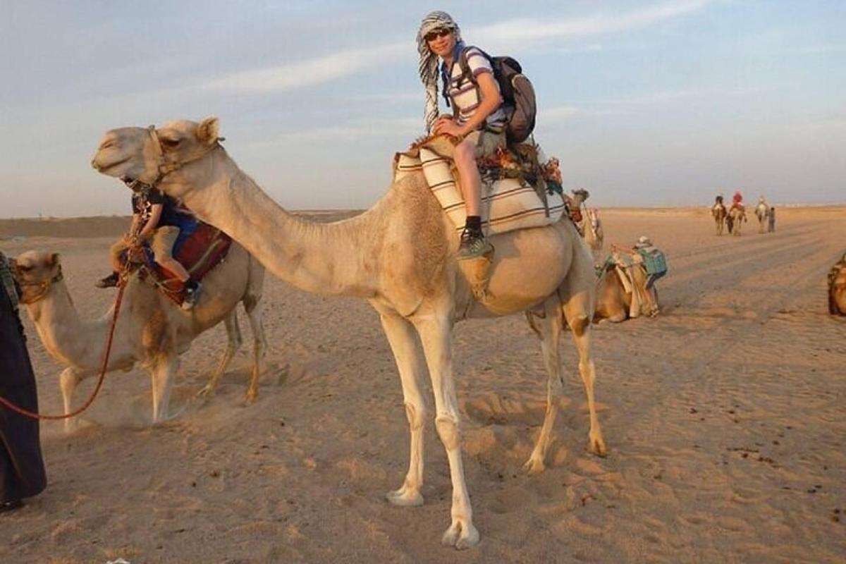 un home muntat en un camell al desert