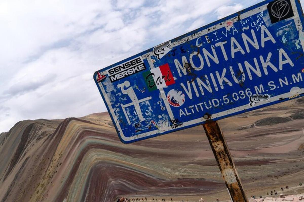 ein blaues Straßenschild an einem Mast mit Aufklebern darauf