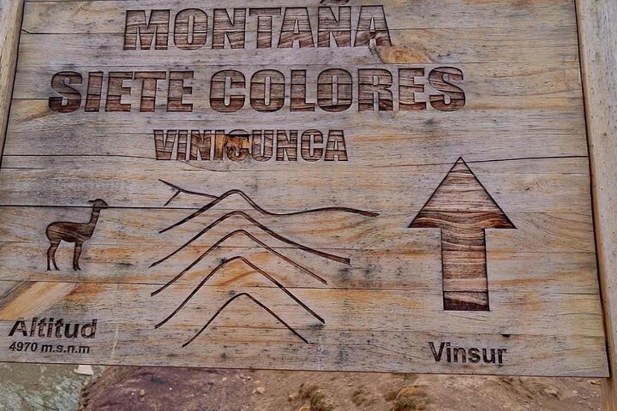 ein Holzschild mit einem Pfeil und ein Schild mit der Aufschrift „Mountain Side Colors“