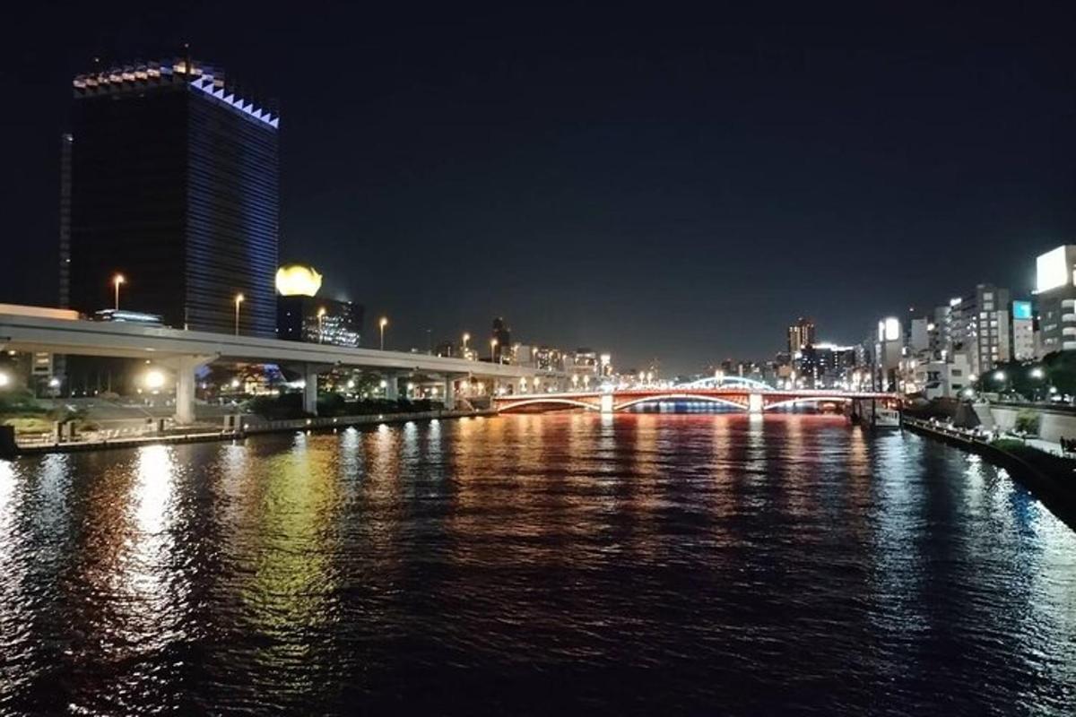 мост преко реке са градом ноћу