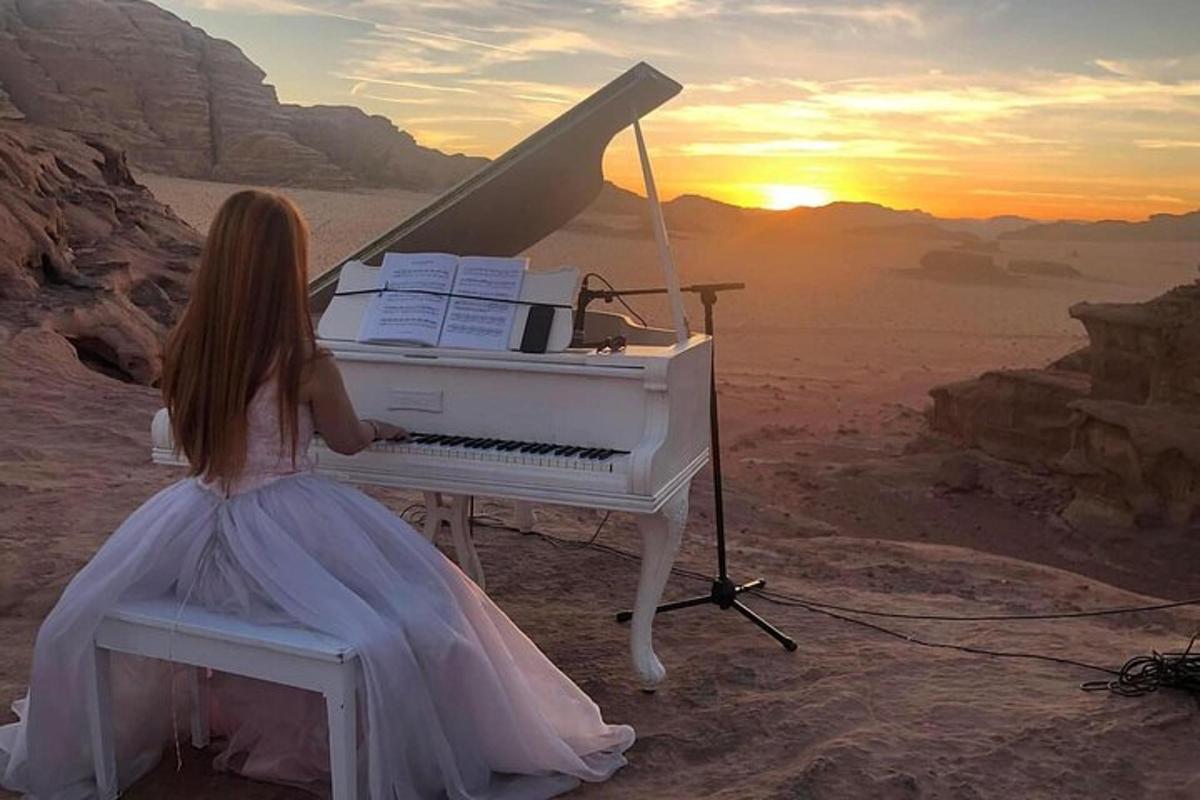 a girl in a dress playing a piano in the desert