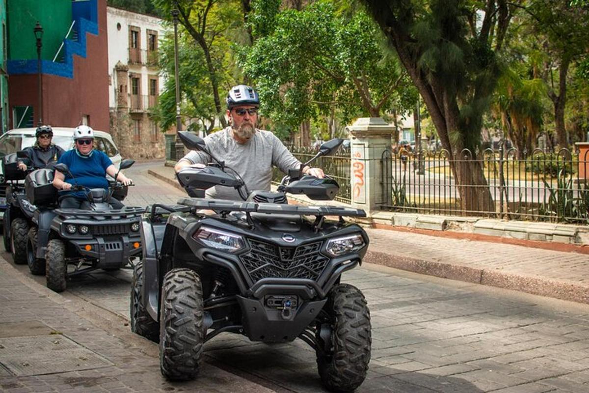 kaks inimest sõidavad ATV-ga mööda linnatänavat