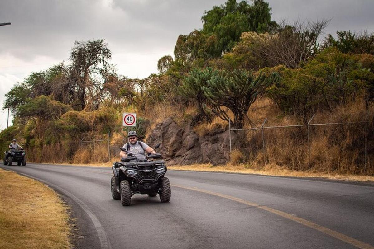a man riding a quad bike down a road