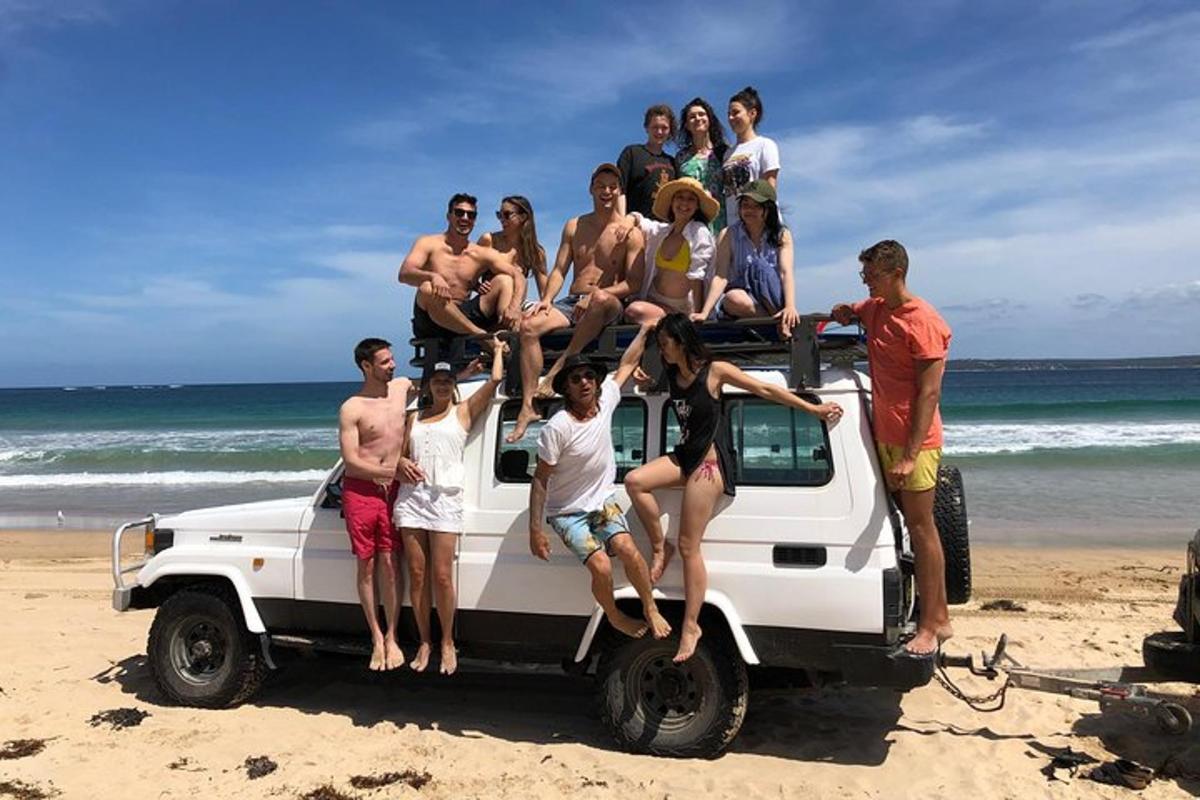 sekumpulan orang duduk di belakang trak di pantai