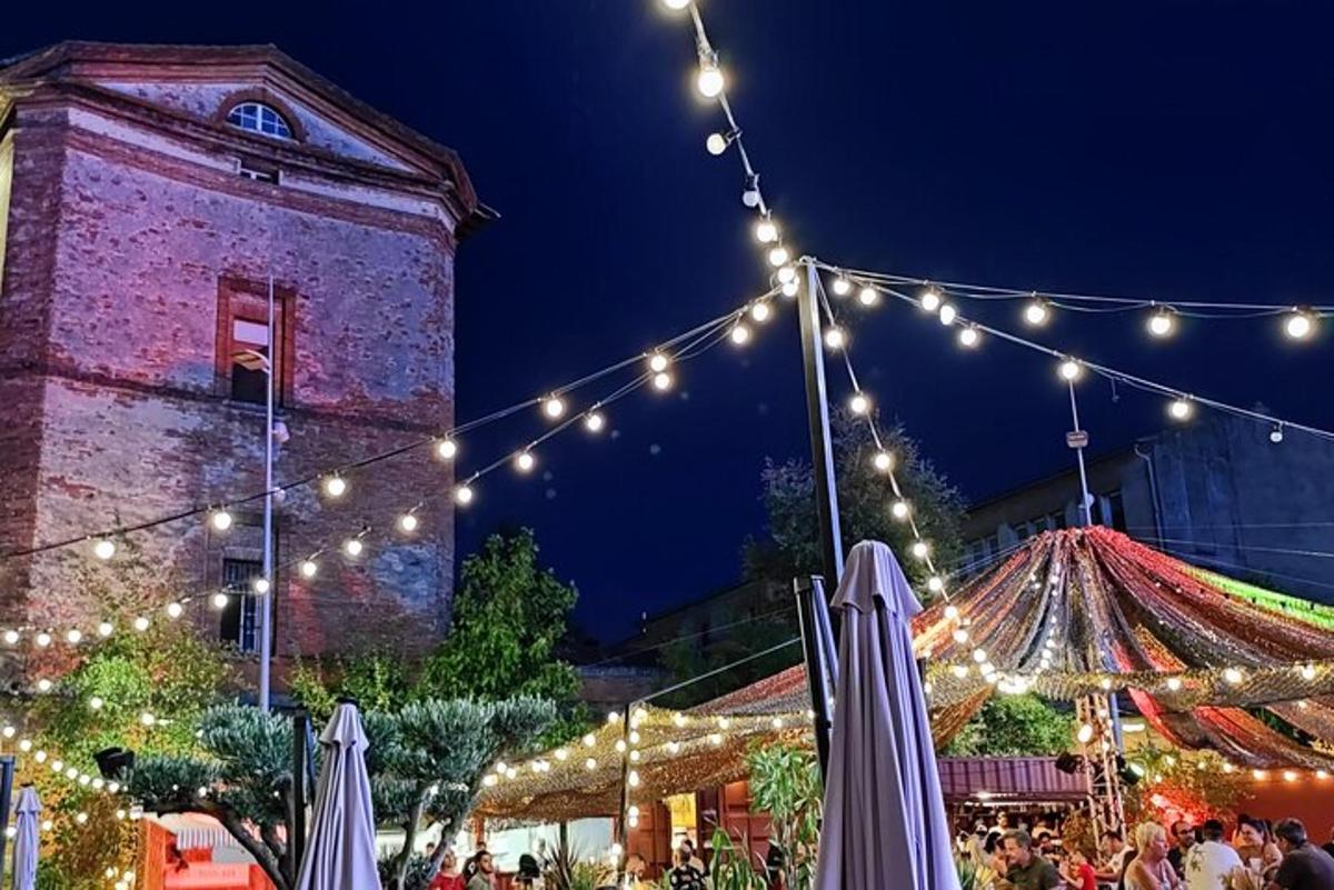 un mercatino di Natale con luci e un edificio