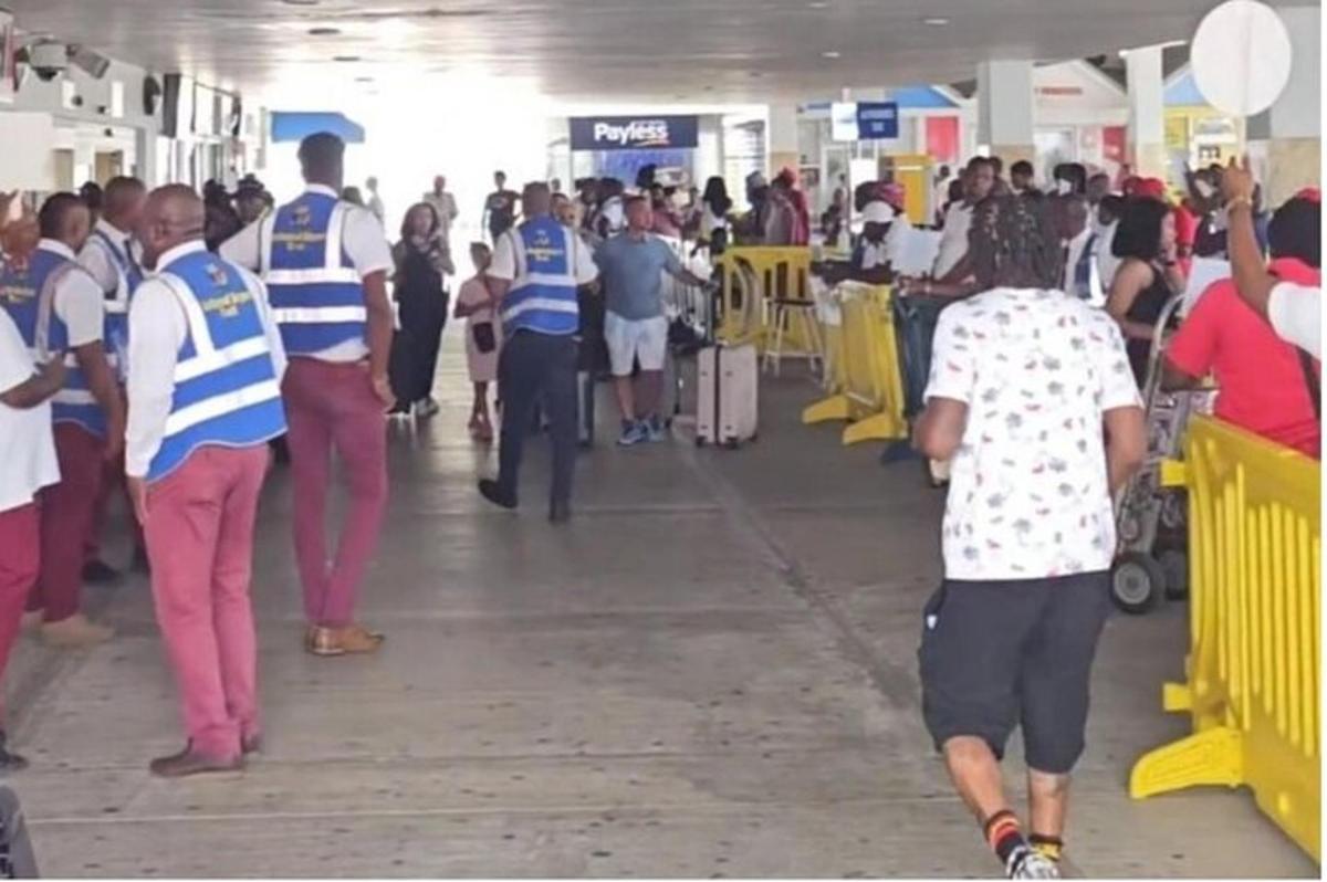 una folla di persone che camminano in un aeroporto