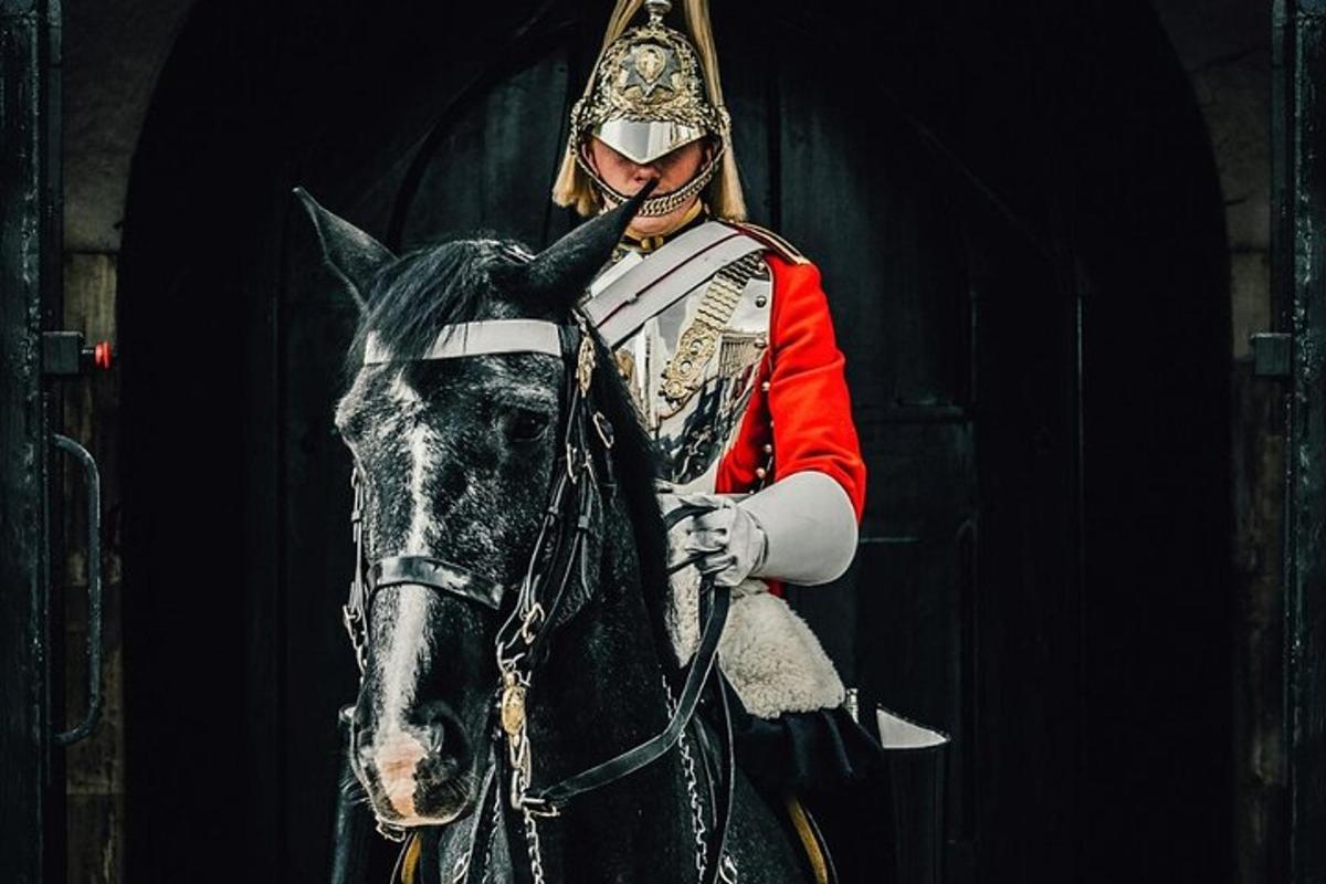 a person dressed in uniform standing next to a horse