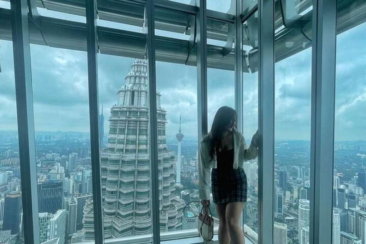a woman standing in a window looking at the city