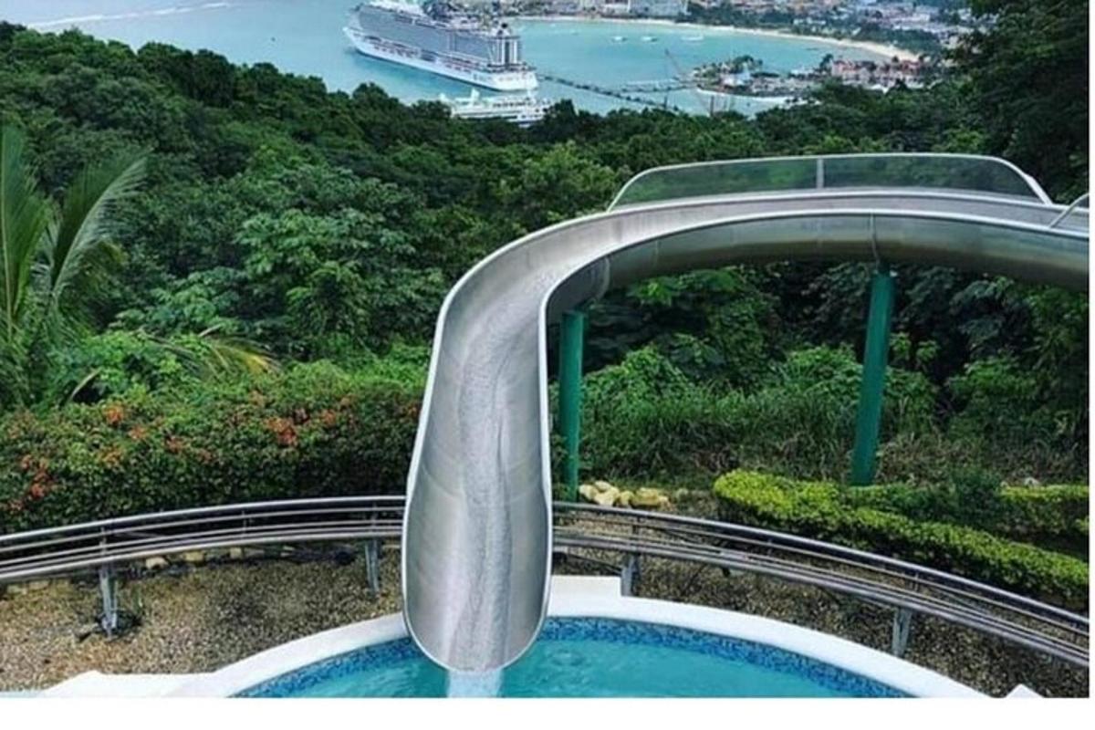 uno scivolo d'acqua curvo con una nave da crociera sullo sfondo