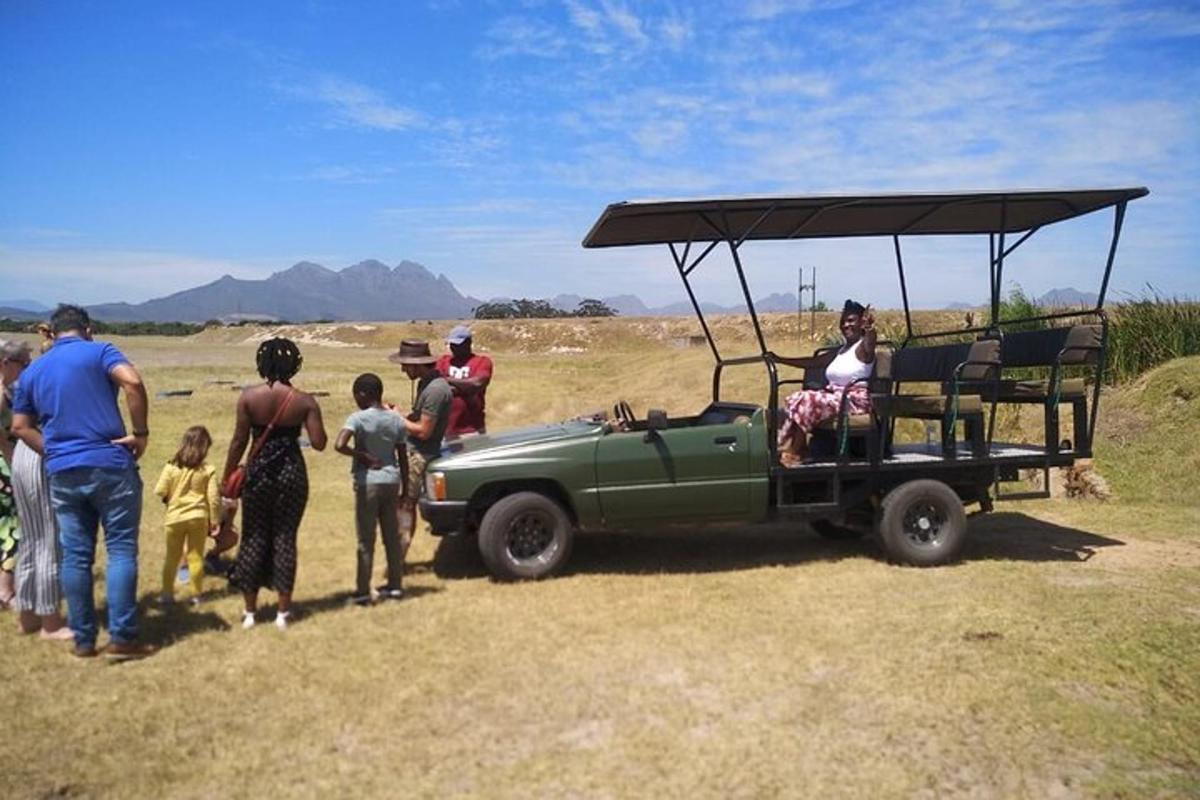 un grup de persones al voltant d'un jeep verd