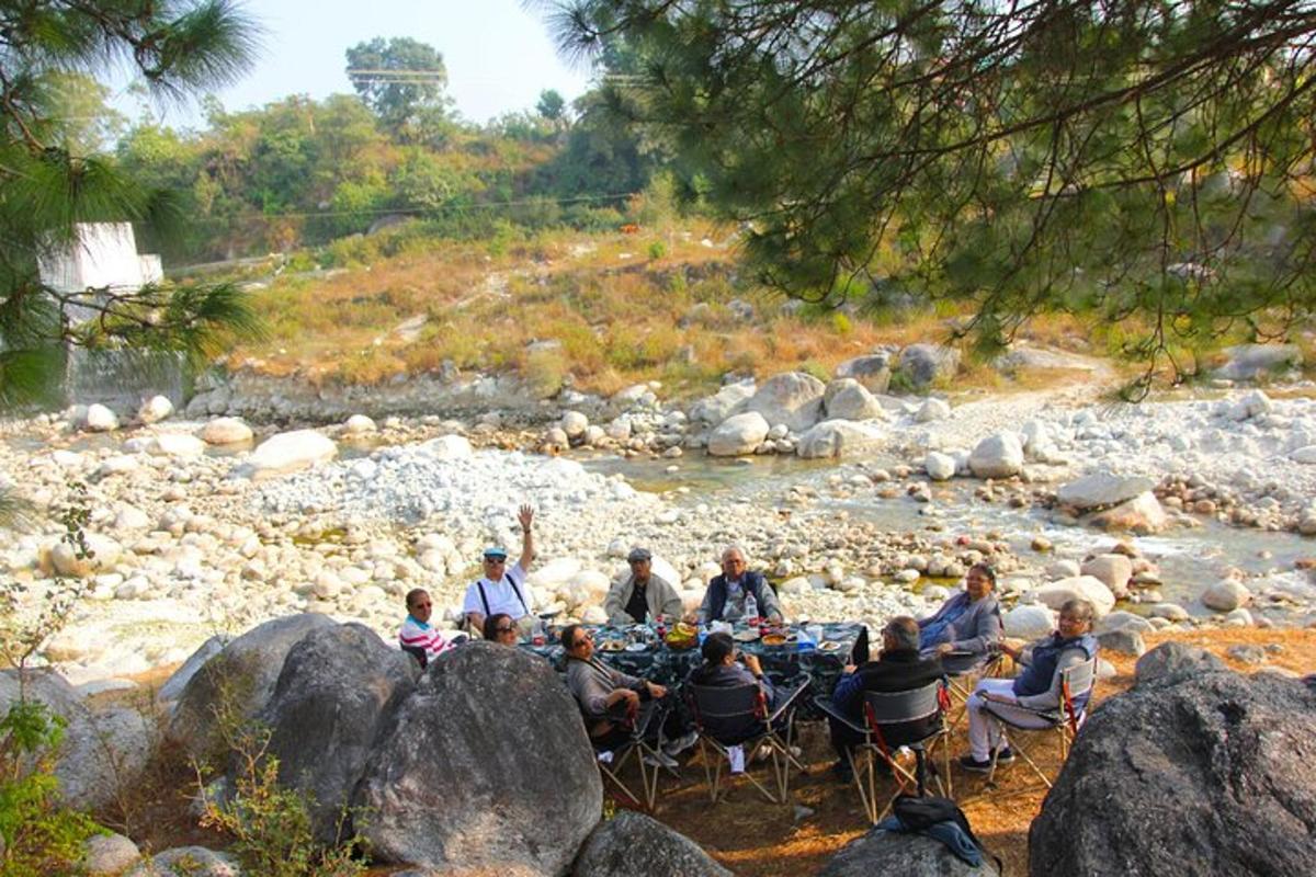 a group of people sitting in chairs by a river
