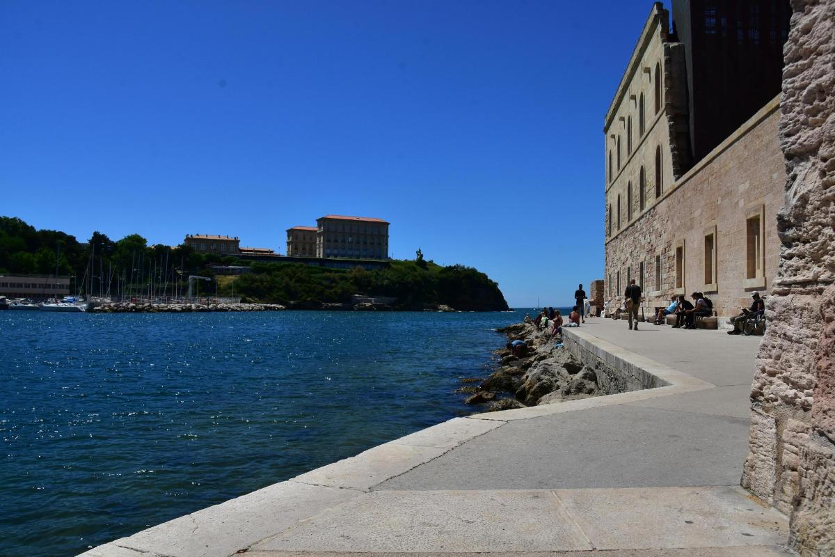 a body of water with people sitting next to a building