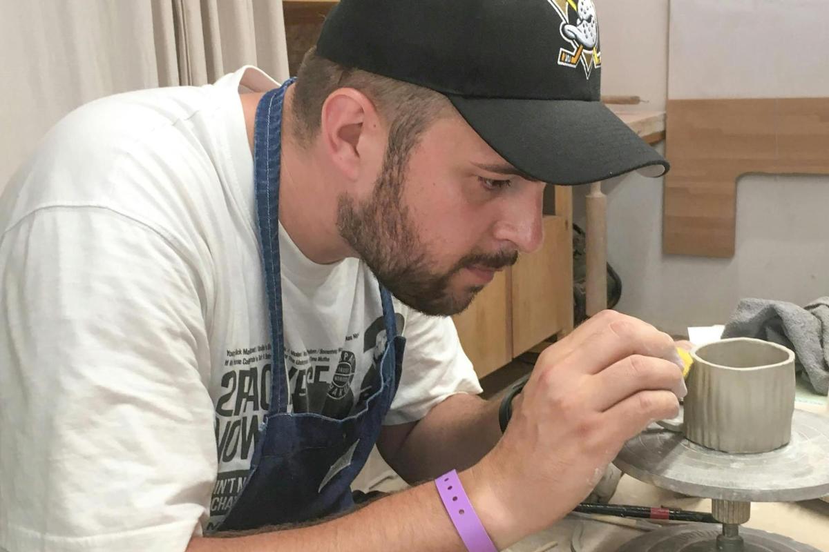 一名男子正在桌上制作杯子