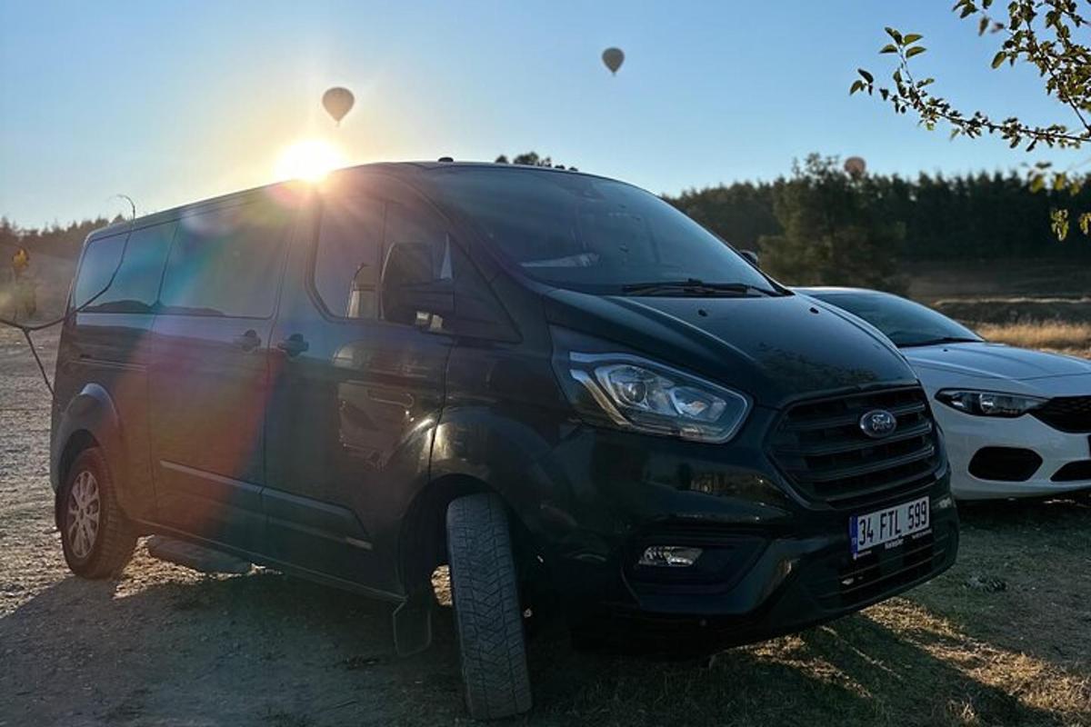 un furgone nero parcheggiato accanto a due auto parcheggiate