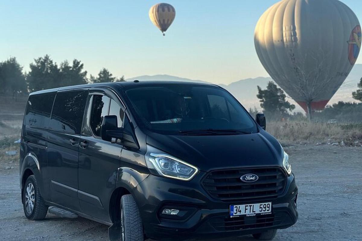 un furgone nero parcheggiato accanto a due mongolfiere