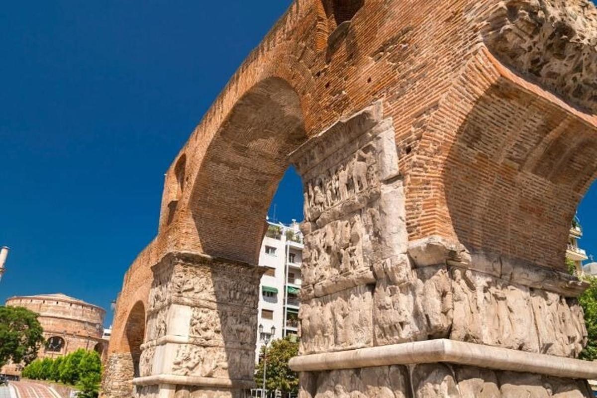 um edifício de tijolos com um arco na frente de um edifício