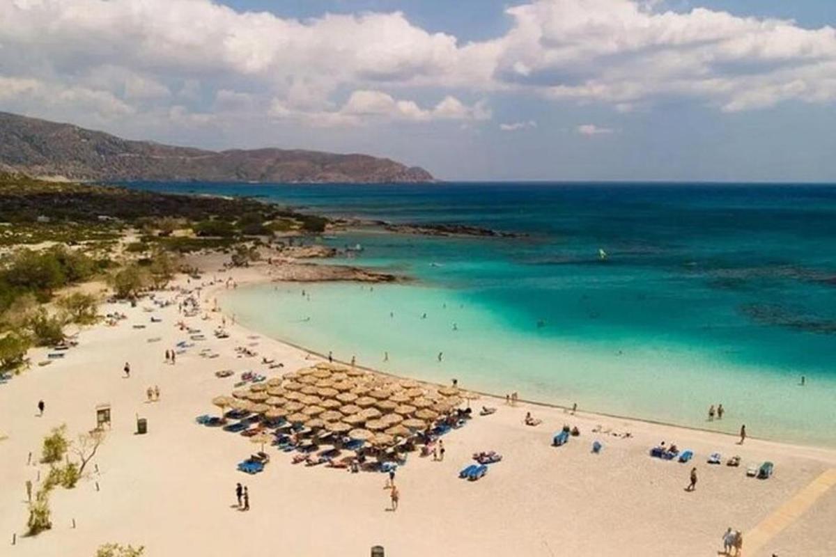 una platja amb para-sols i gent a l'aigua