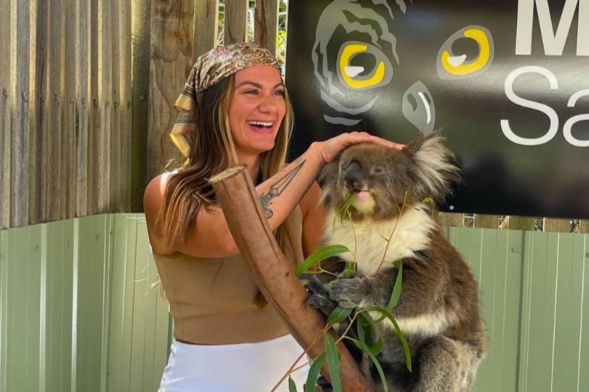 una donna tiene in braccio un cane con un bastone
