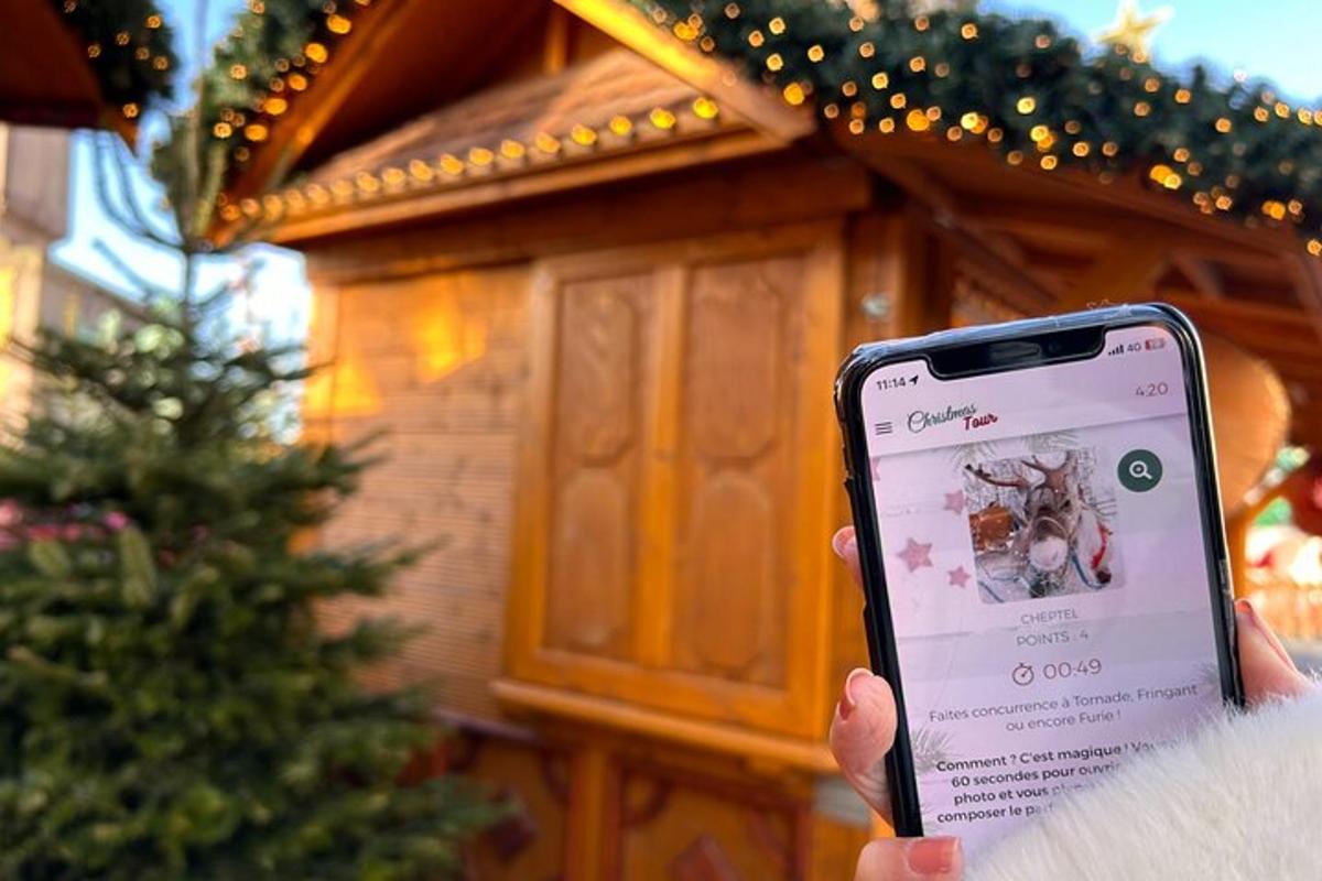 osoba držící mobilní telefon před domem