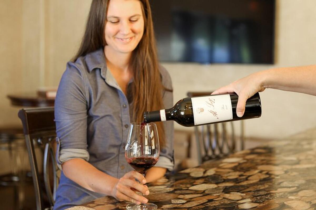 a woman pouring a glass of red wine