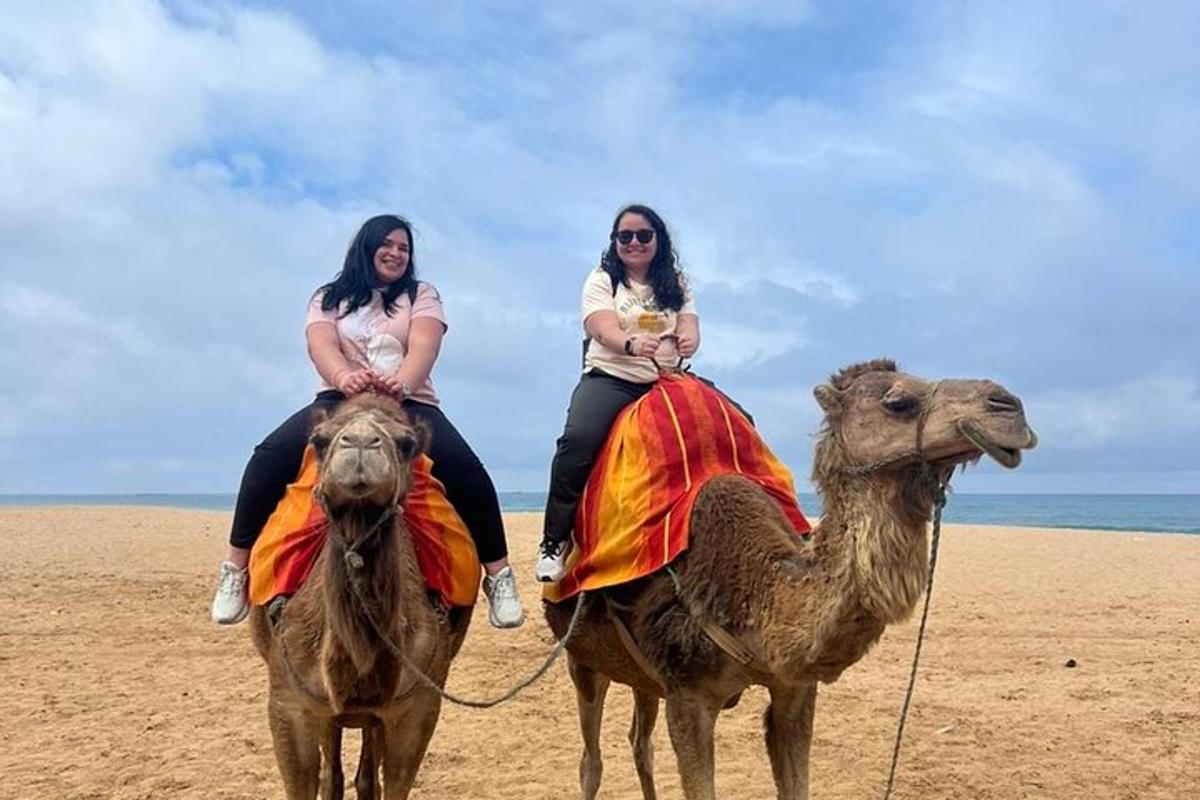 dua wanita menaiki unta di pantai