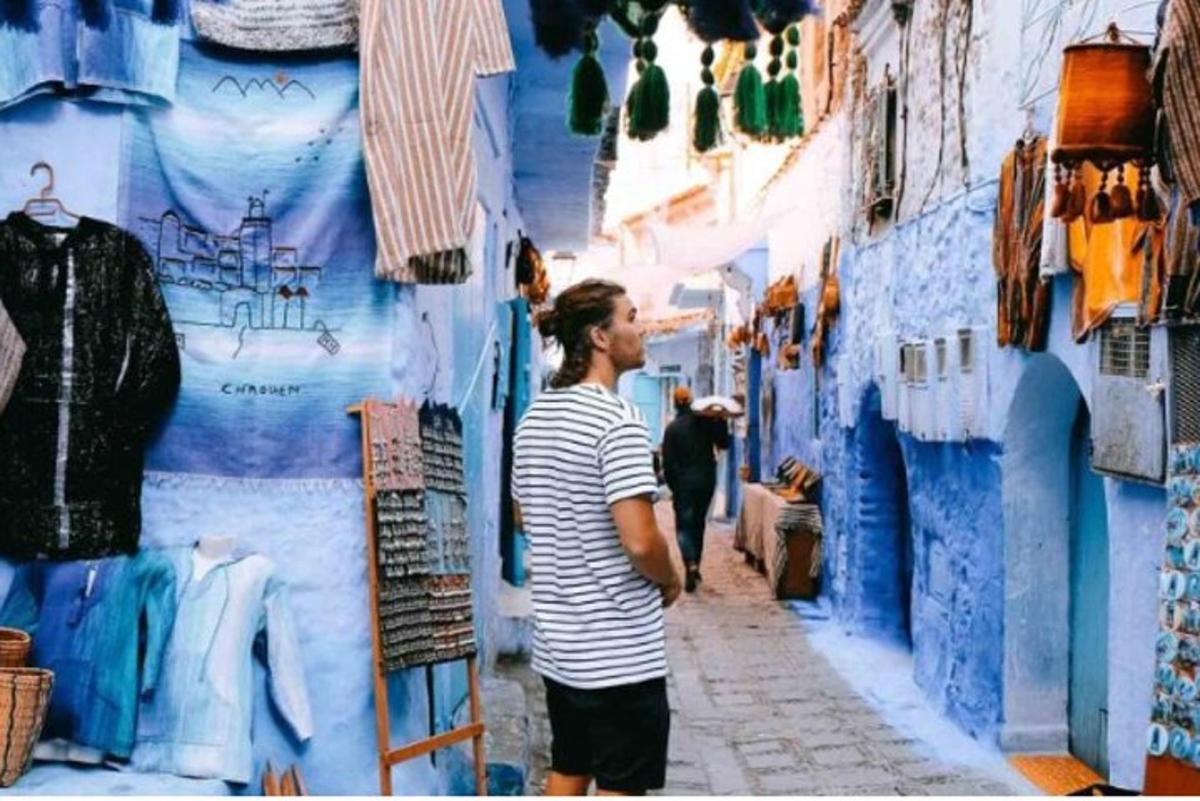 un home caminant per un carreró blau