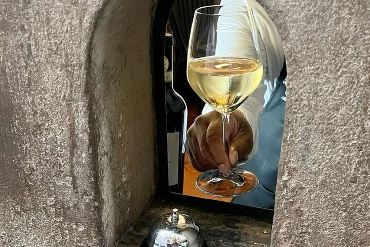 una persona che tiene in mano un bicchiere di vino bianco