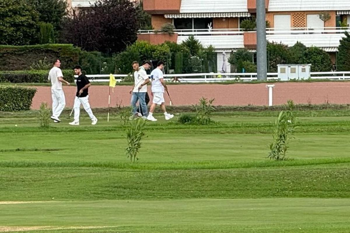 skupina ljudi, ki hodijo po igrišču za golf