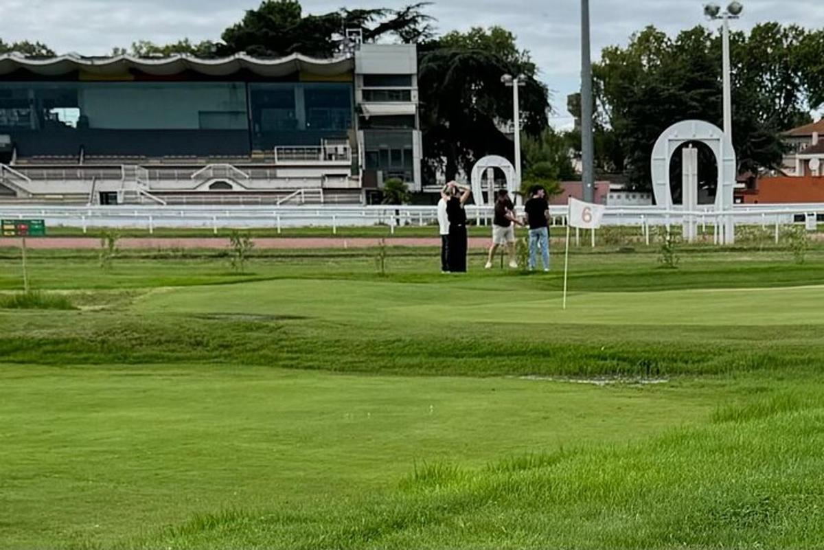 skupina ljudi, ki stojijo na igrišču za golf