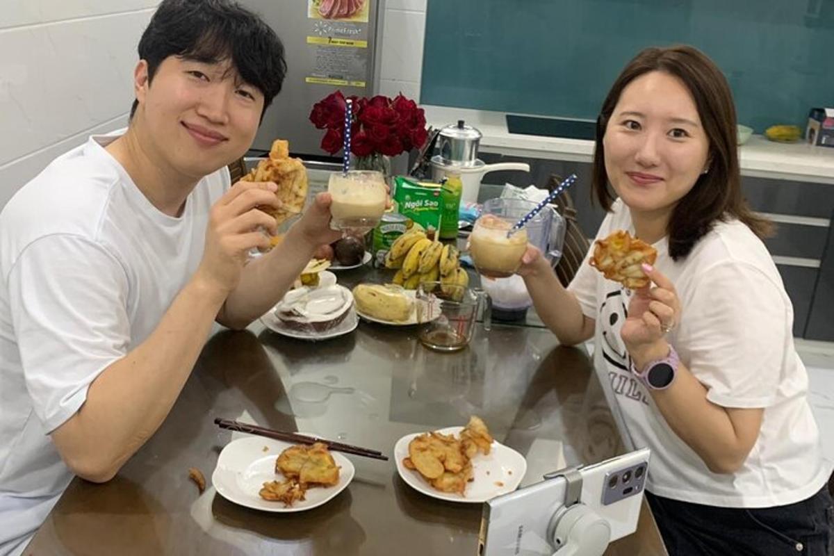 Un hombre y una mujer sentados en una mesa comiendo comida