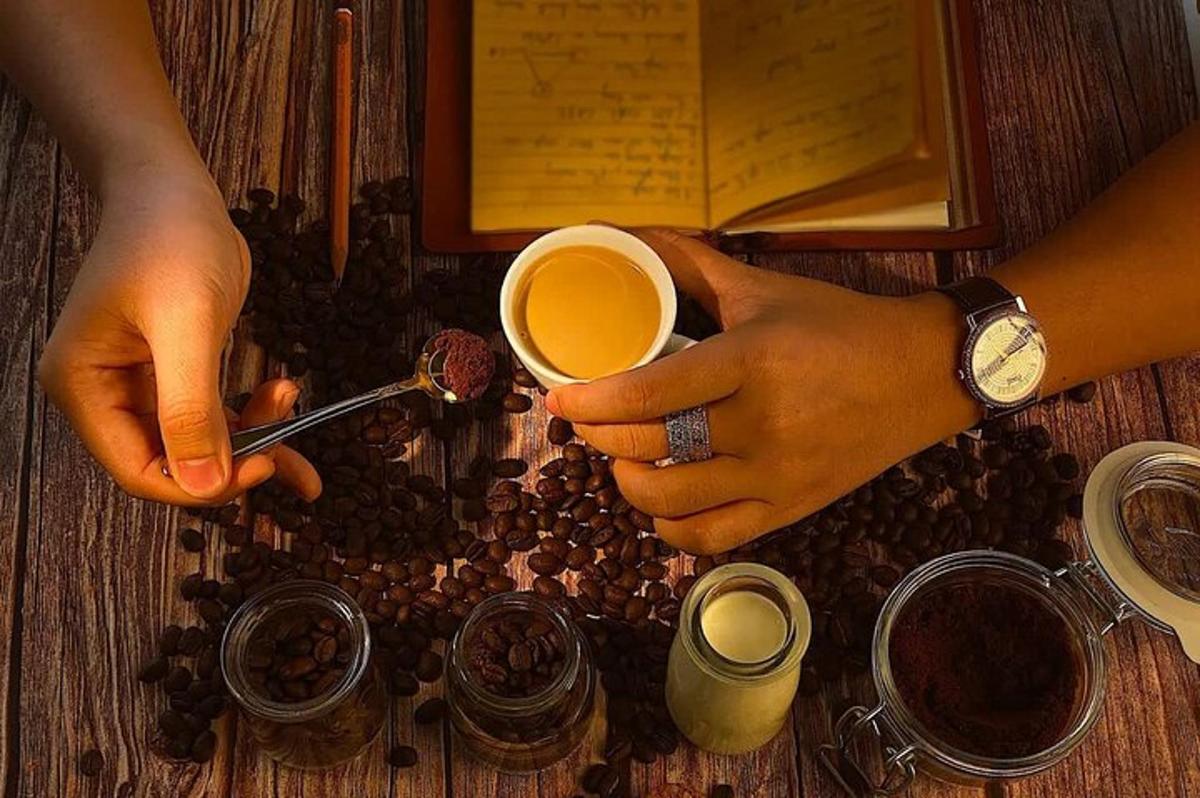una persona sosteniendo una taza de café sobre una mesa