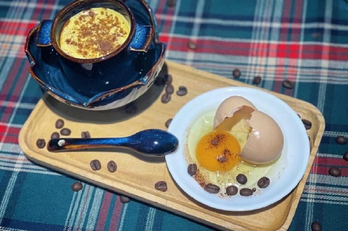 Un plato de huevos y una taza de café en una bandeja.