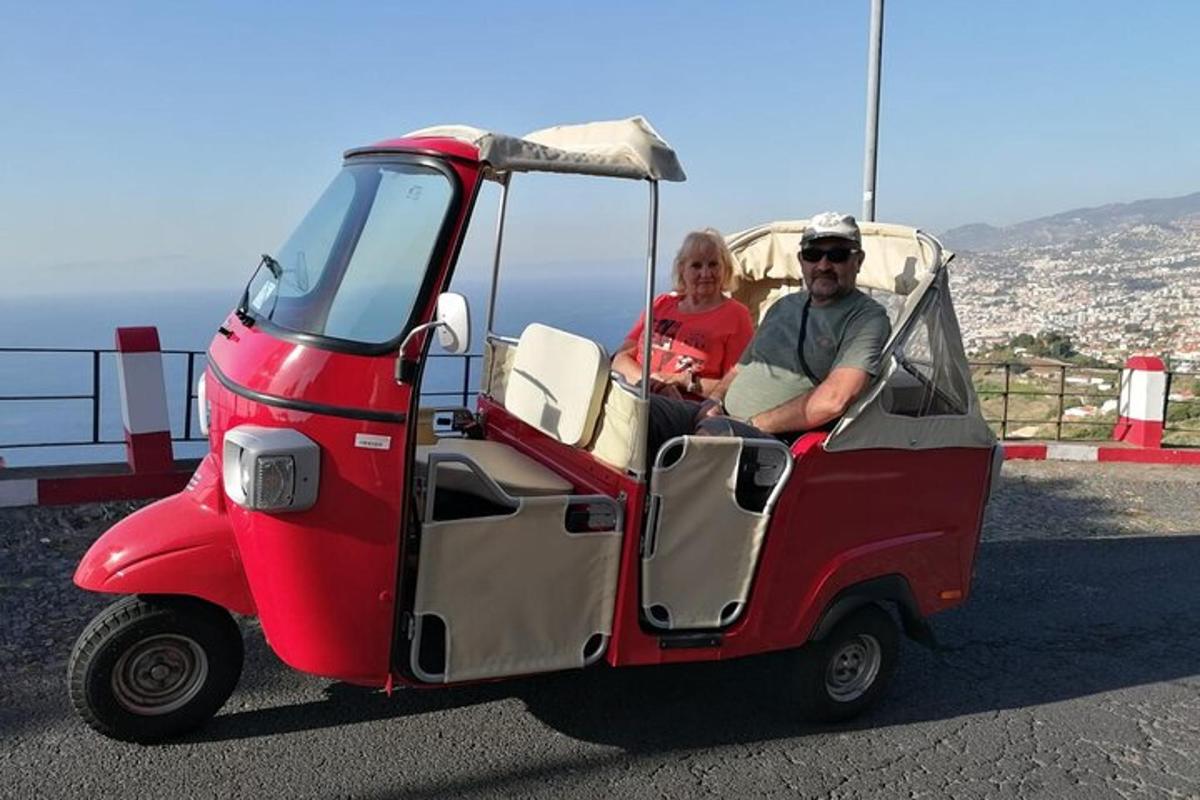 un uomo e una donna seduti in un piccolo golf cart