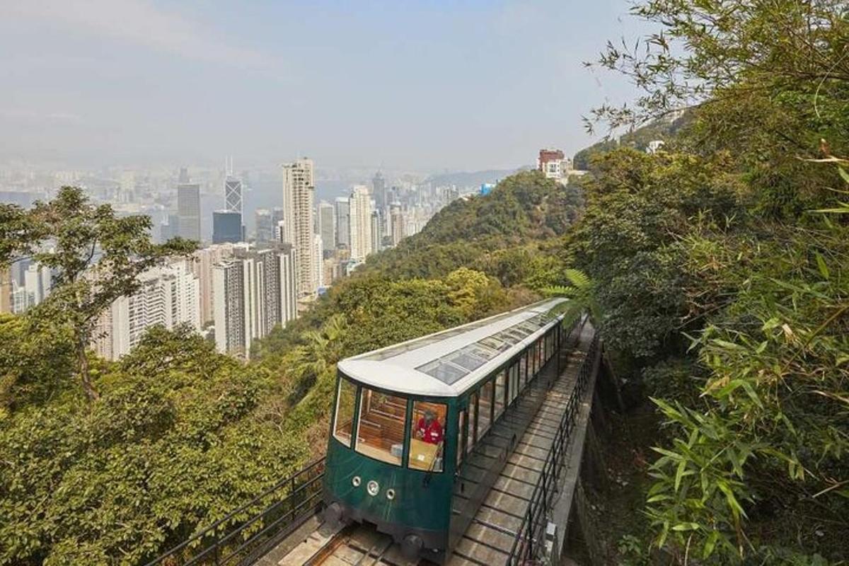 a green train on a track in a city