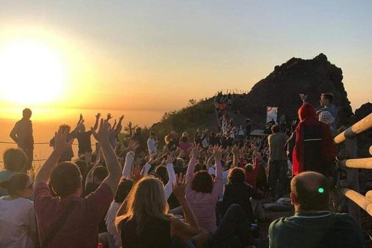 a crowd of people watching a concert at sunset