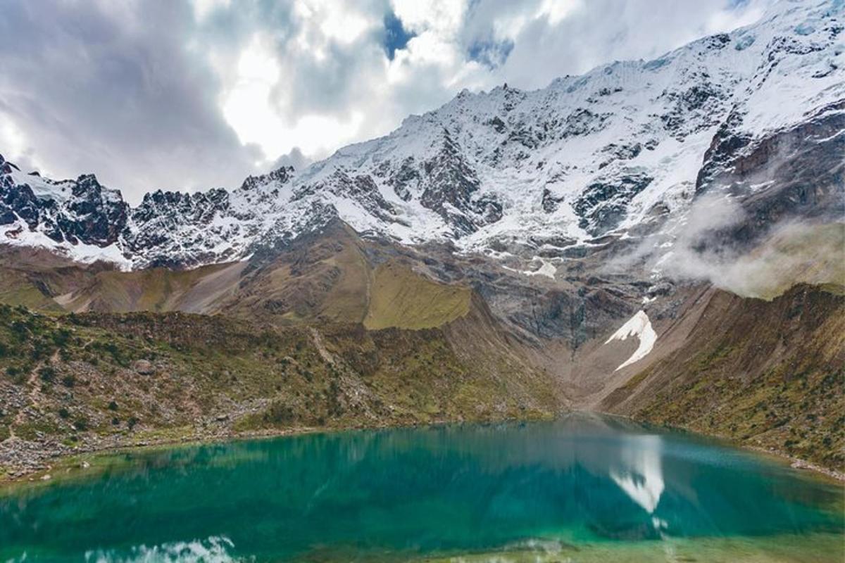 una montagna con un lago blu di fronte