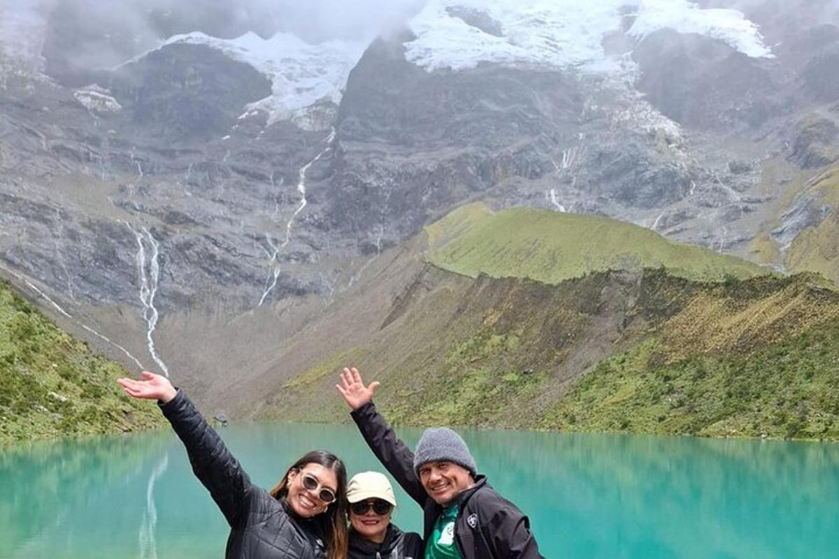 tre persone in piedi davanti a un lago di montagna
