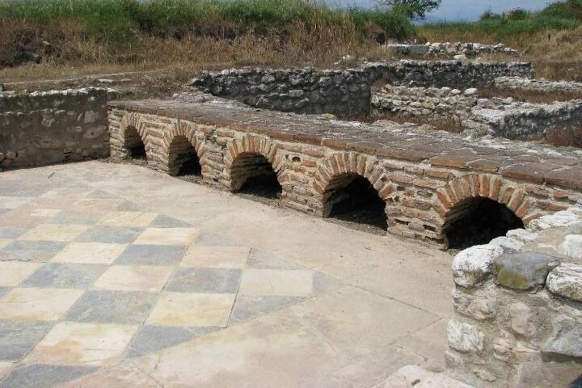μια πέτρινη γέφυρα με δύο σήραγγες σε ένα χωράφι