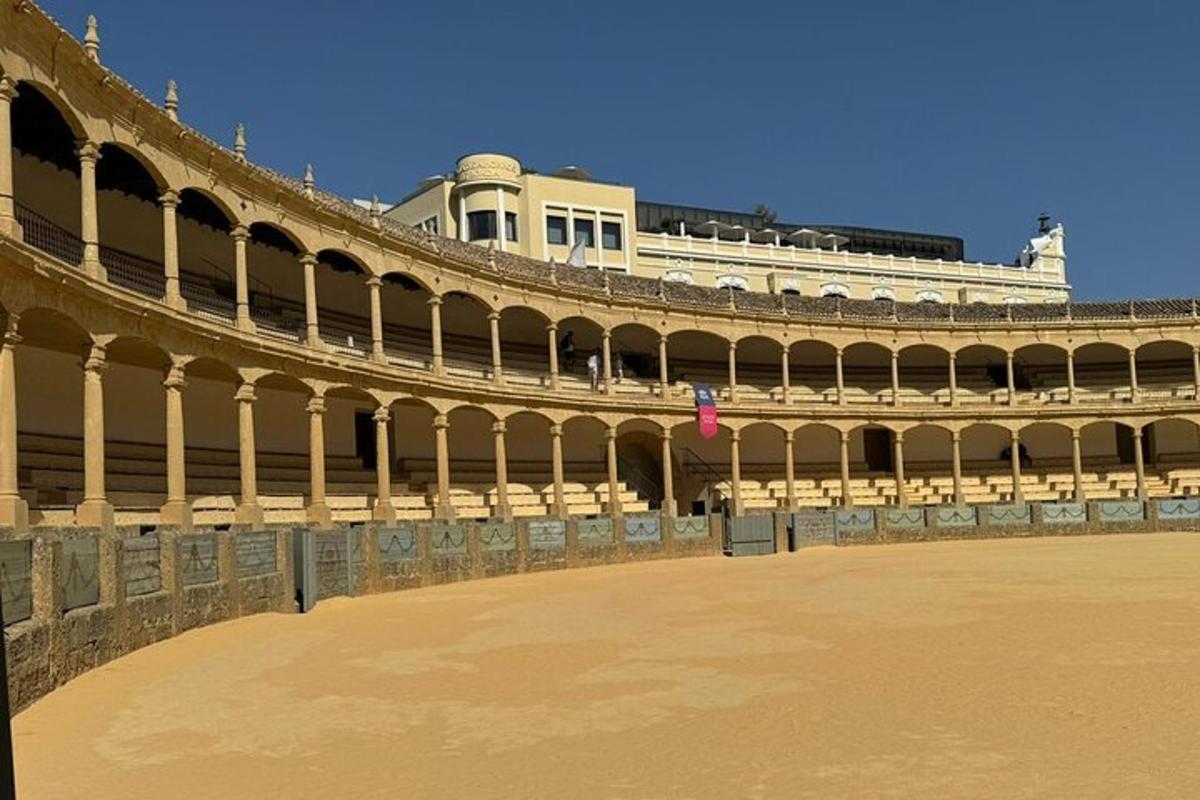 Un gran edificio con un gran patio con sillas.