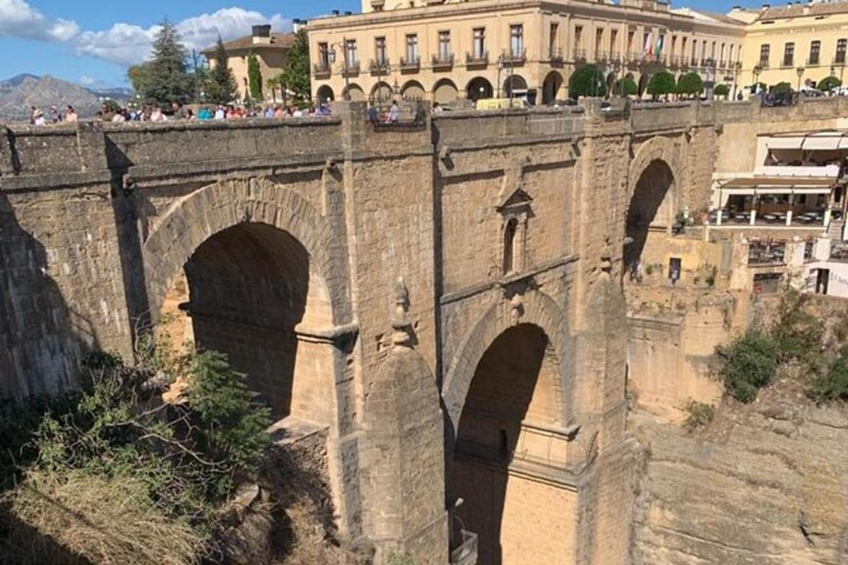 Un puente de piedra con tres arcos y un edificio.