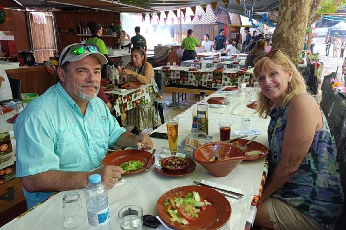 um homem e uma mulher sentados à mesa com comida