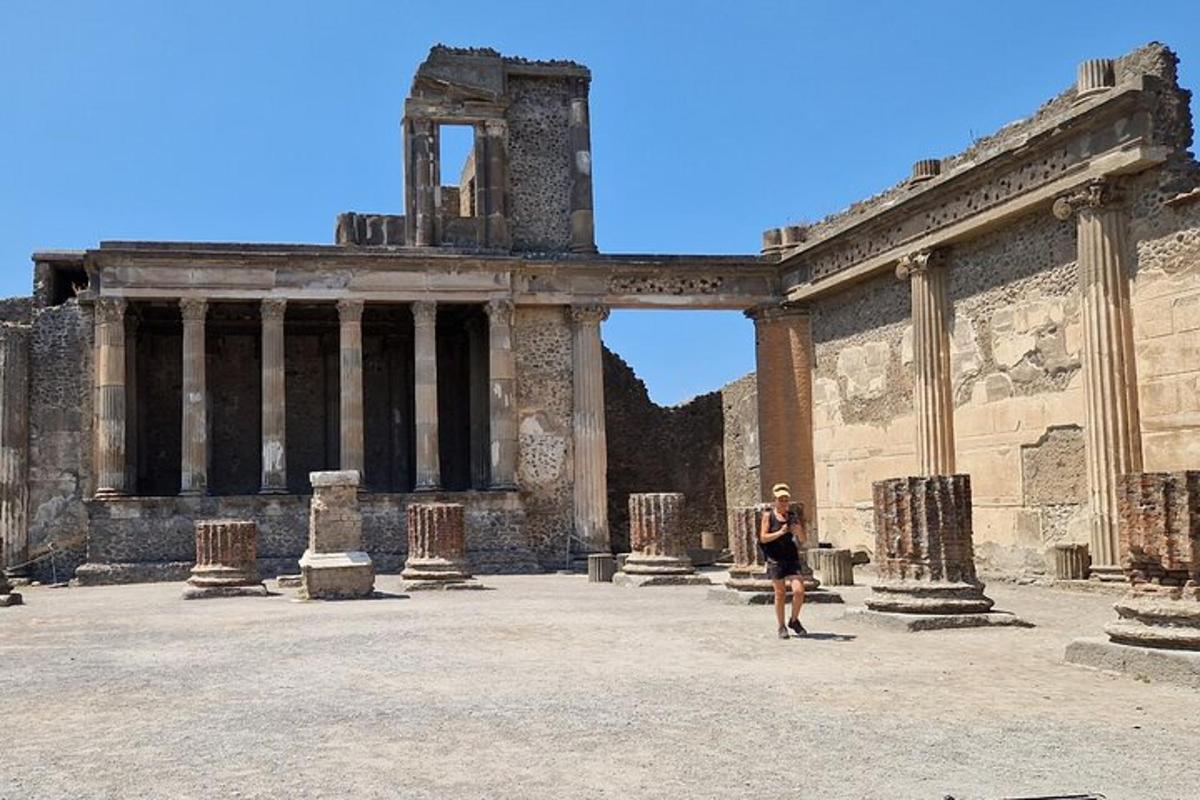 a woman walking in front of an ancient building