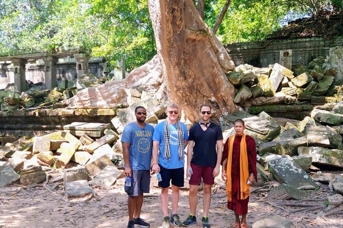 Un grupo de hombres de pie frente a un árbol.