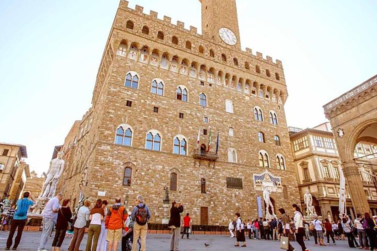 un gruppo di persone in piedi davanti a un edificio con una torre dell'orologio