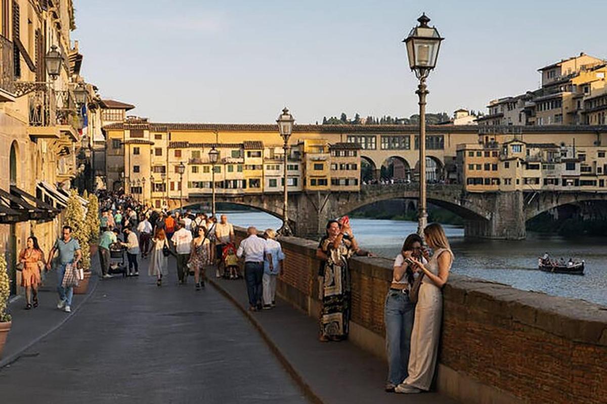 una folla di persone che camminano su un ponte sopra un fiume