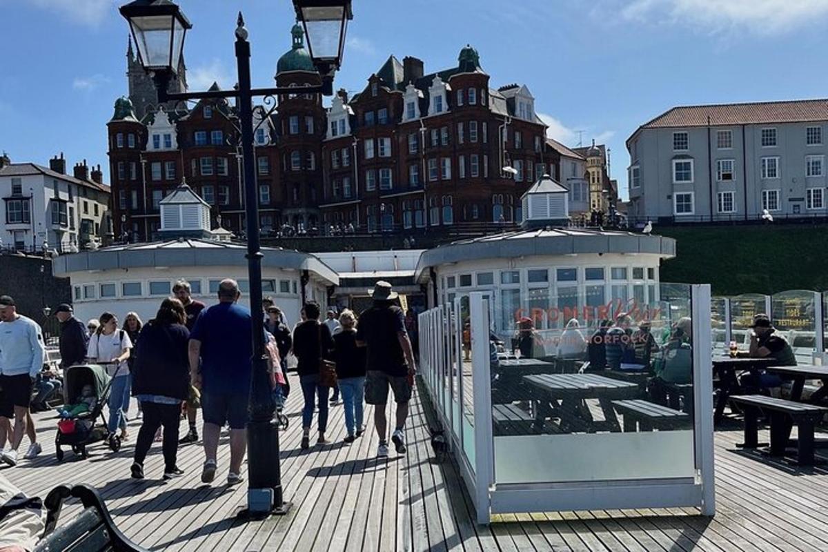a group of people walking on a pier with a building